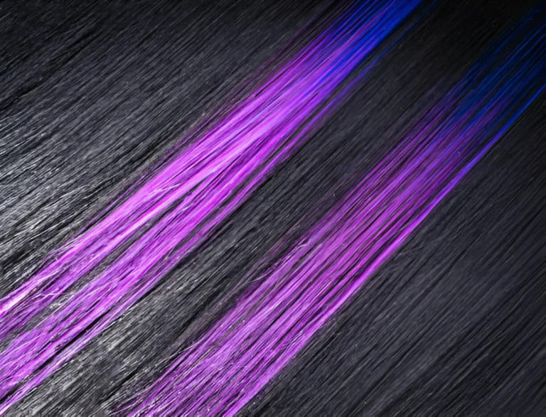 A close-up of black hair with highlights, featuring vibrant purple streaks that contrast sharply against the dark base, creating a bold, dynamic look.