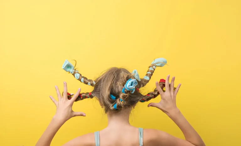 Girl with colorful, twisted braids showing off a fun and creative hairstyle for crazy hair day ideas against a bright yellow background.