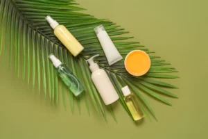 A collection of skincare products, including sprays, creams, and oils, arranged on a green background with a palm leaf.