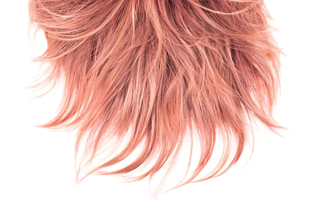 A close-up of rose gold hair with a textured, wavy appearance against a white background.