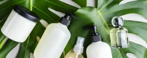 A collection of Haircare products, including sprays, creams, and oils, arranged on a green background with a leaf.