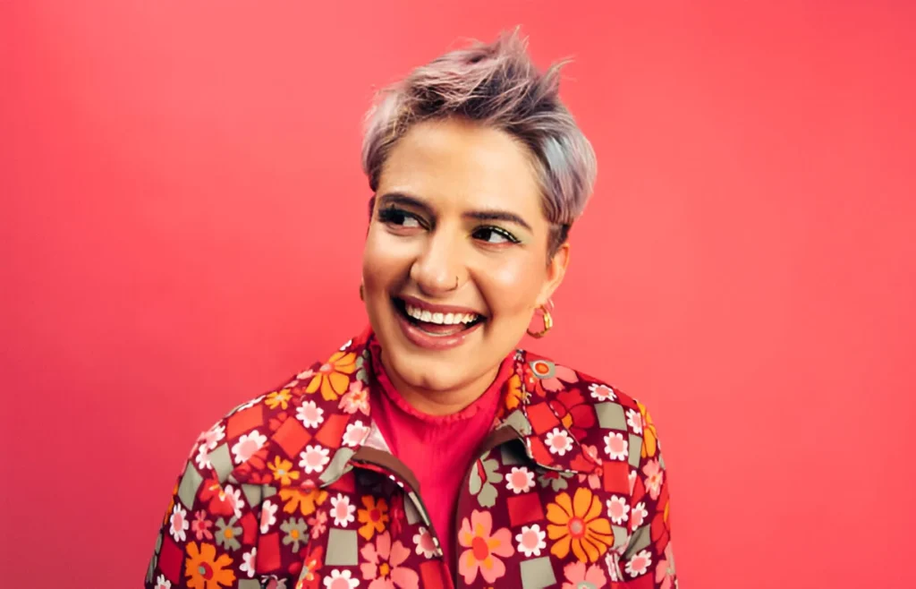 Discover how to style short hair with a bold and vibrant look, featuring a colorful floral jacket and a playful purple hairstyle.