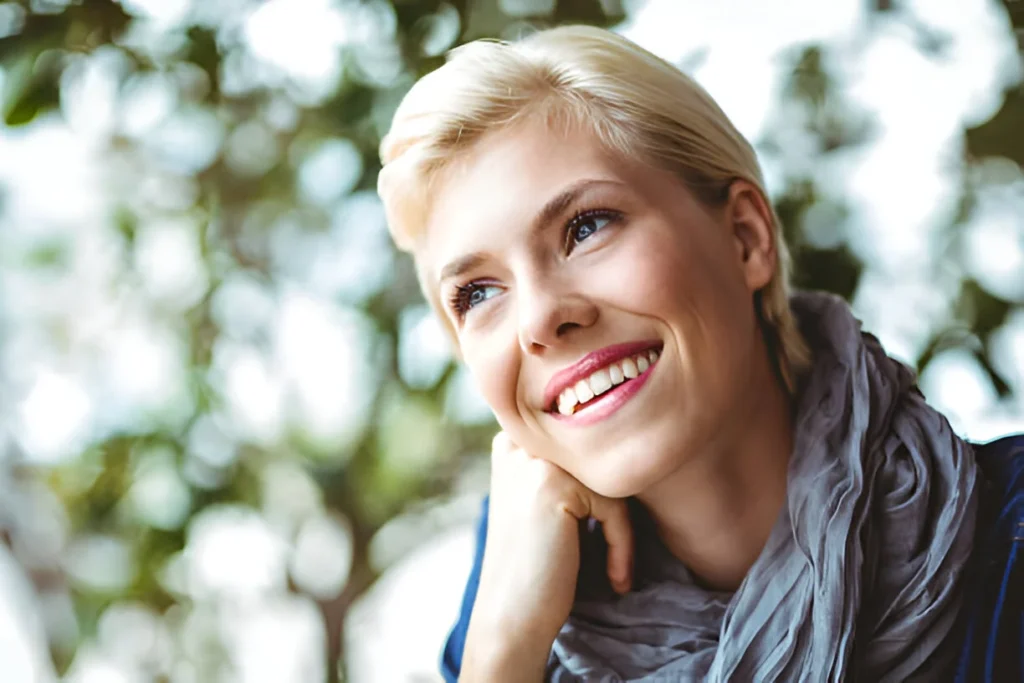 Learn how to style short hair with a casual and charming look, featuring a gray scarf and a relaxed outdoor setting.